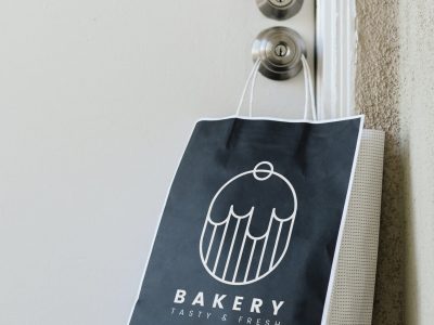 Contactless delivery bakery bag mockup hanging on a doorknob dur Contactless delivery bakery bag mockup hanging on a doorknob during the coronavirus pandemic