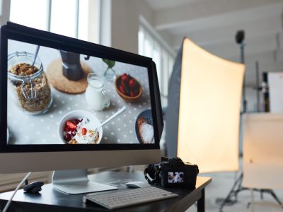 Stock photography production Workplace of photographer with computer monitor and photocamera